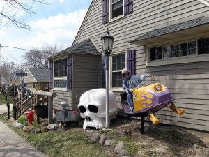 Snowmobile, skull, and motorboat stern displayed in Cudahy, Wisconsin front yard