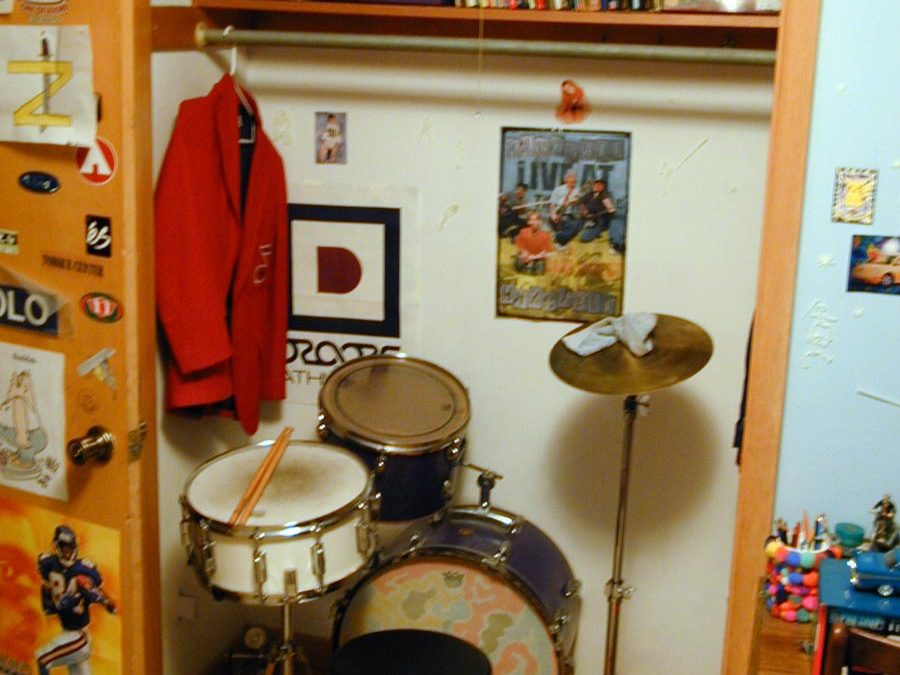 Drum kit and red school band jacket in closet