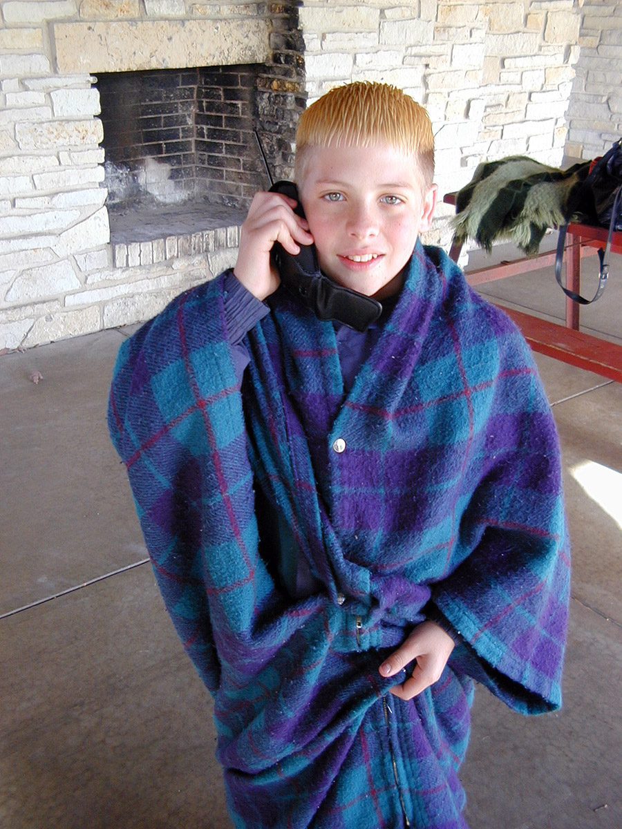 Elliot on the phone wearing a snap blanket at Silver Lake Park in Salem, Wisconsin