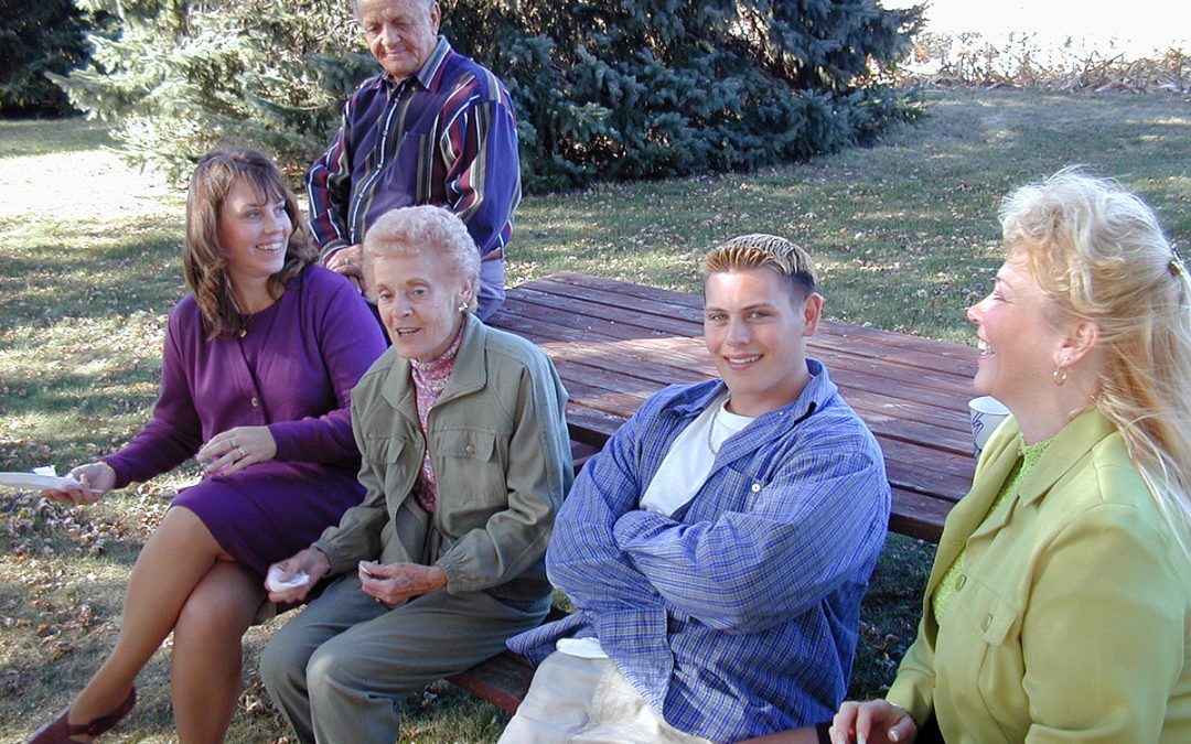 Smiling family members at a backyard picnic table in Wisconsin