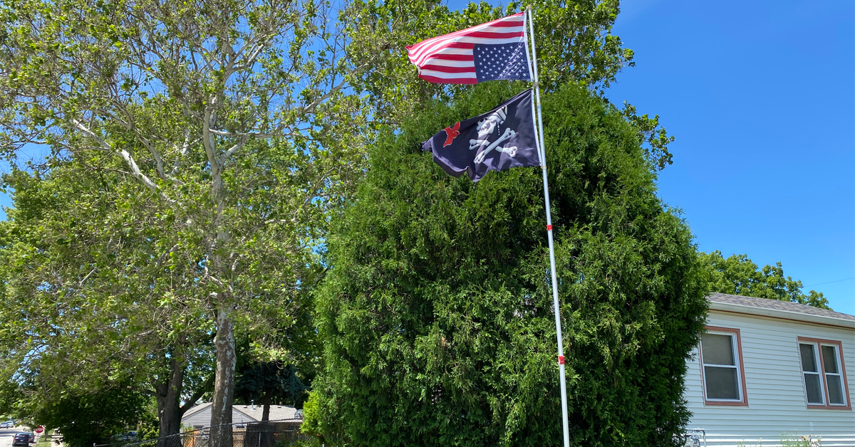 upside-down American flag with Jack Sparrow flag on a flagpole in Racine, Wisconsin